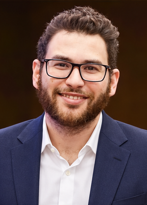 Dr. Haitham Sharshar in a navy suit and white open-collar shirt.